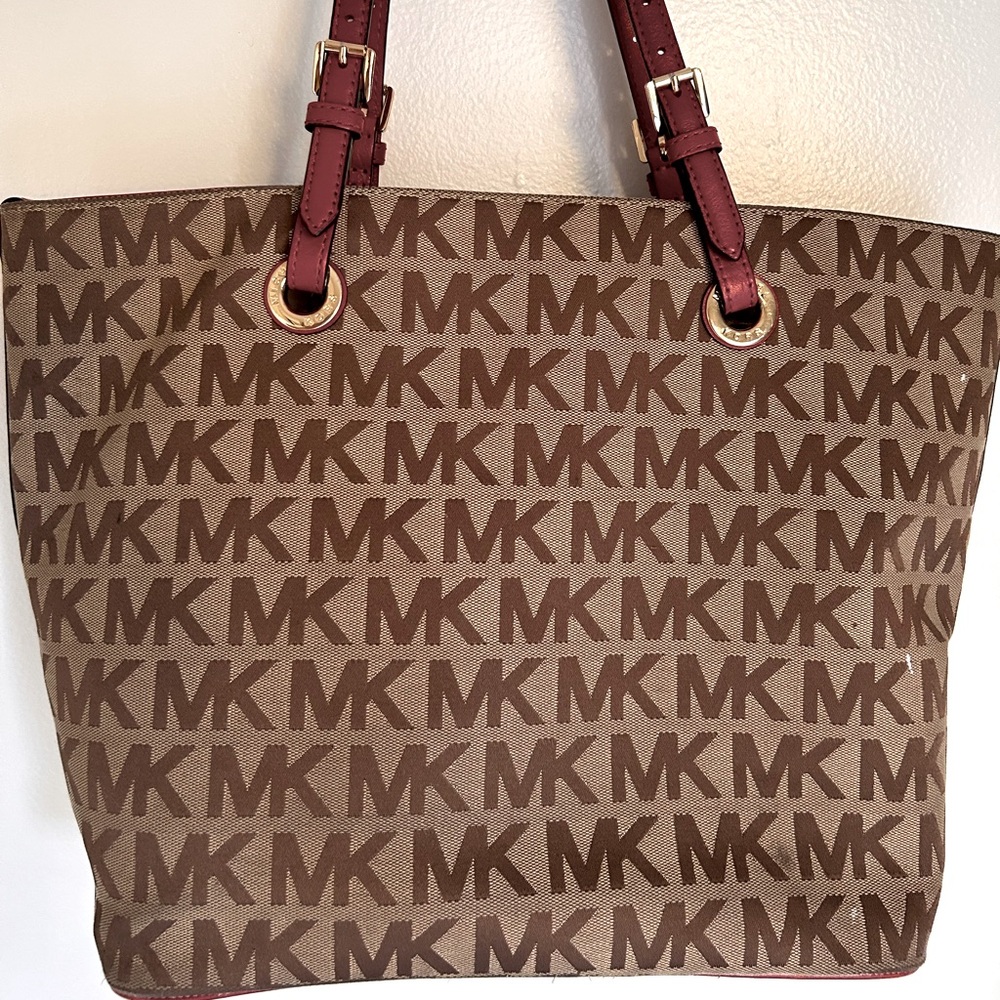 Beautiful gently used signature Michael Kors purse with Red leather accents.